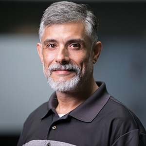 Edward J. McFadden, wearing a grey collared shirt and smiling