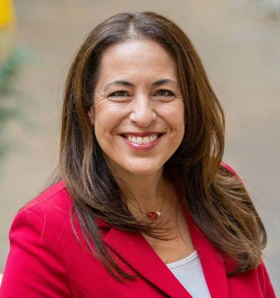 AnnaMaria Gounaris, Wearing a red suit with a white shirt and a bright smile