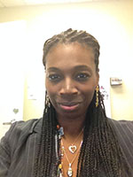 Women with braided hair and Jewelry smiles at the camera 