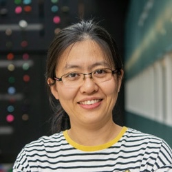 Person wearing glasses and a striped shirt, smiling into the camera