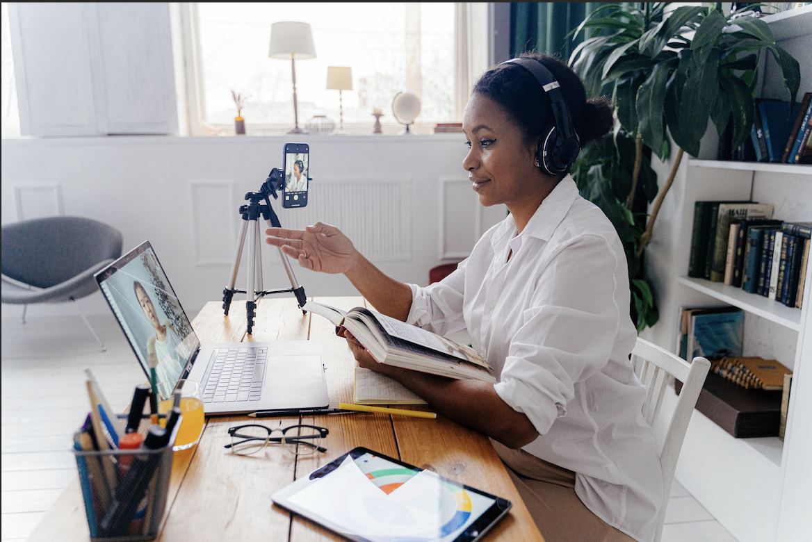 A woman teaches remotely as a student attends class virtually