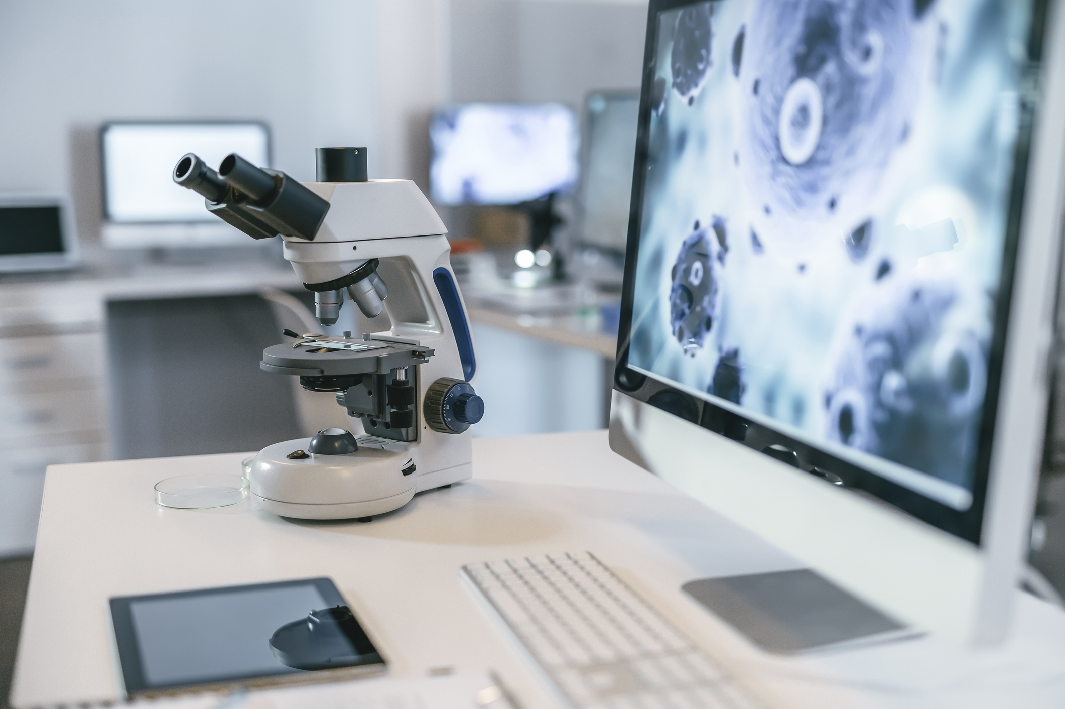 Microscope with computer screen in background