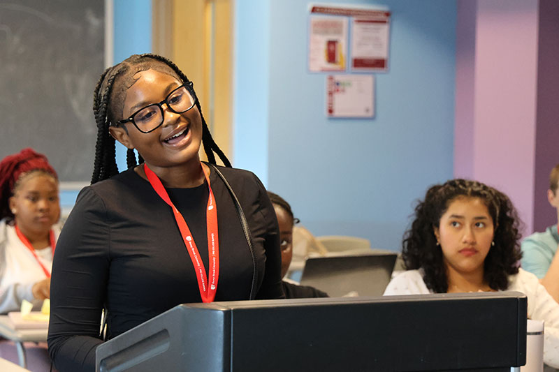 Student giving a presentation at a lectern